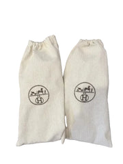 Two white drawstring bags with a logo on a wooden surface