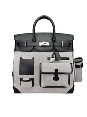 A structured black and white leather handbag with silver-tone hardware, featuring a top handle, front flap pocket, and zippered side pocket, photographed on a plain white background.