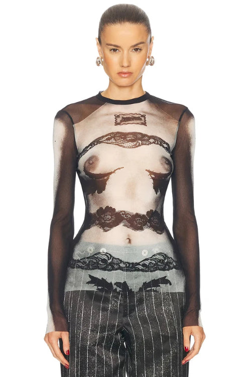 Model wearing a sheer top with lace details and pinstripe pants on a white background