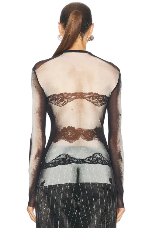 Back view of a person wearing a sheer black lace top with long sleeves on a white background