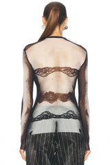 Back view of a person wearing a sheer black lace top with long sleeves on a white background