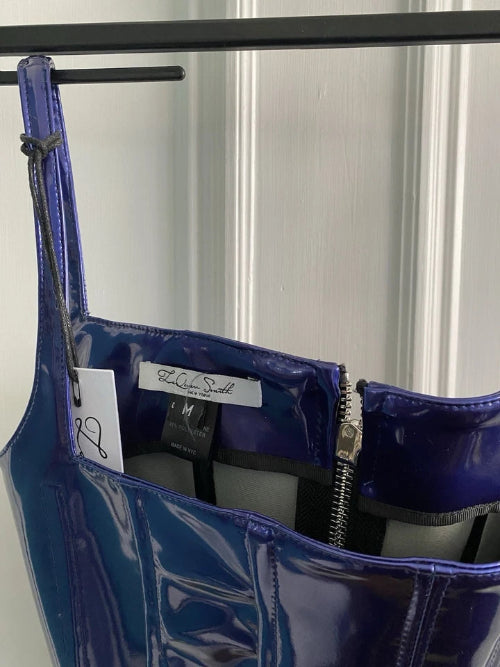 Blue patent leather handbag with a visible brand label on a white background
