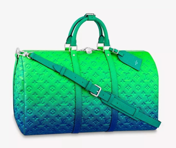 Green and blue duffel bag with monogram pattern on a white background