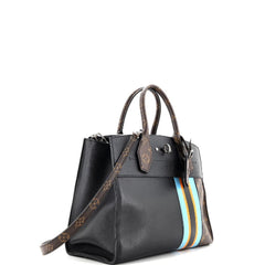 Black handbag with a striped strap on a white background