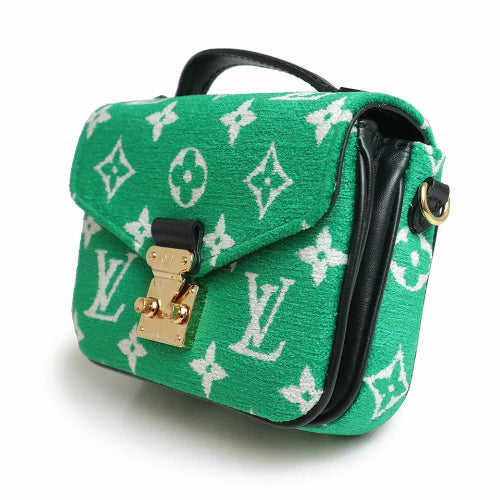 Green handbag with white monogram pattern on a white background
