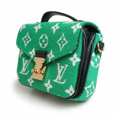 Green handbag with white monogram pattern on a white background