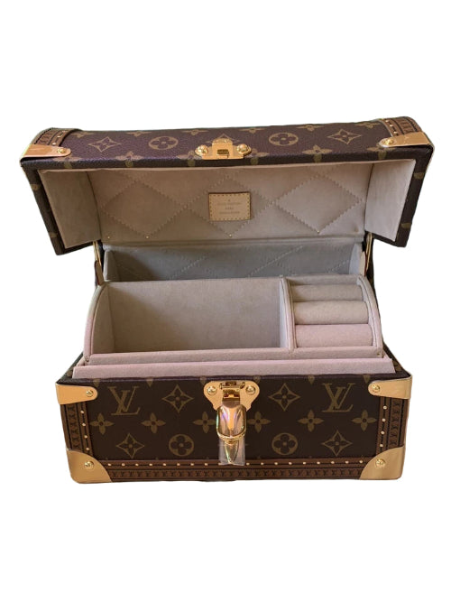 Open jewelry box with a monogram pattern on a white background