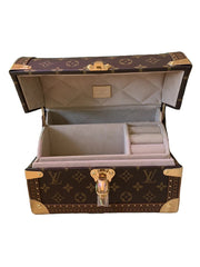 Open jewelry box with a monogram pattern on a white background