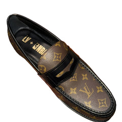 Louis Vuitton shoe with NBA logo held in front of an orange Louis Vuitton box.