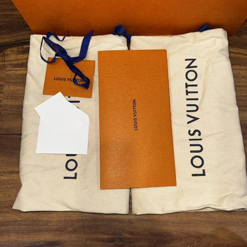 Louis Vuitton packaging with orange card and white paper on a wooden surface