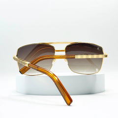 Gold-framed sunglasses with brown gradient lenses on a white background