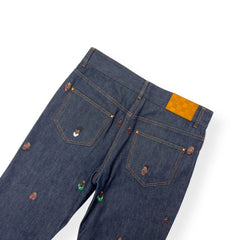 Blue denim jeans with a yellow patch on a white background