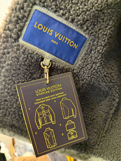 Louis Vuitton jacket with a branded tag and instruction card on a textured surface.