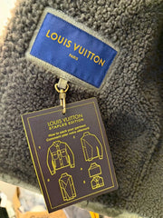 Louis Vuitton jacket with a branded tag and instruction card on a textured surface.