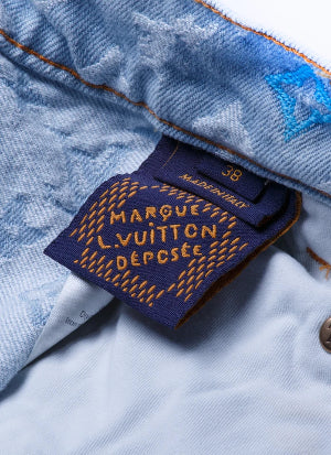 Close-up of a light blue denim jacket showing the inner collar, a blue embroidered star patch, and a dark navy brand label with gold embroidery reading 'MARGUE L.VUITTON ÉPOSÉE' and 'MADE IN ITALY'.