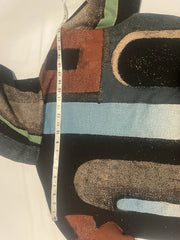 Colorful patterned rug with a measuring tape for scale on a light background