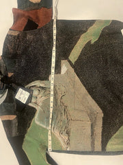 Camouflage-patterned fabric with a measuring tape for scale on a white background