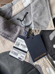 Close-up of a gray coat with a visible brand tag on a white background