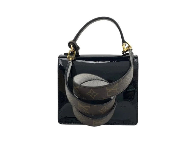Black handbag with gold accents on a white background