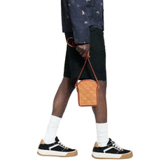 Person holding a brown leather bag with a plain background