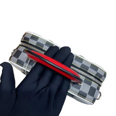 Red tool on a checkered surface with a black glove partially covering it
