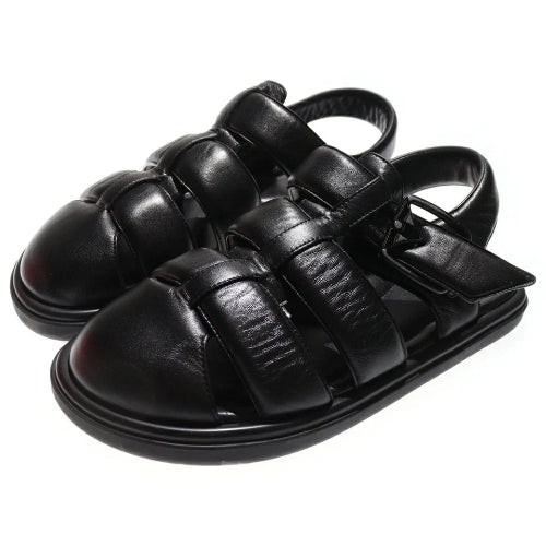 Black leather sandals with strap details on a white background