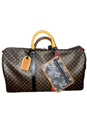 A Louis Vuitton monogram canvas duffel bag with tan leather handles and a matching zippered luggage tag, displayed on a wooden surface against a gray textured wall.
