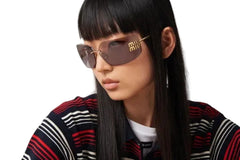 Person wearing sunglasses and a striped sweater with a blurred background