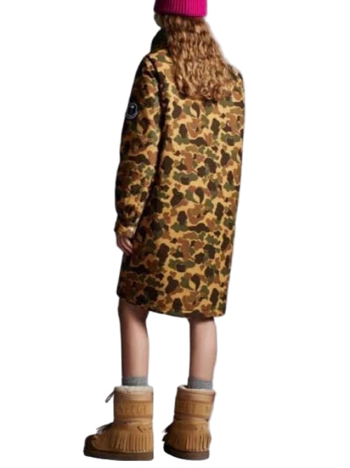 Person wearing a leopard print coat and brown boots on a plain background