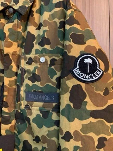 Camouflage jacket with Palm Angels and Moncler patches on a wooden background