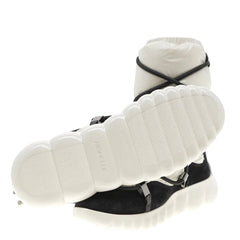 White and black sneaker with criss-cross design on a white background