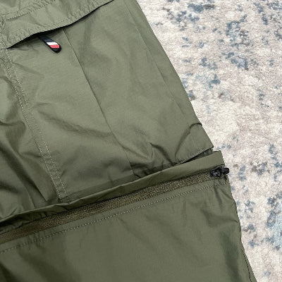 Close-up of green pants with a zipper on a textured surface