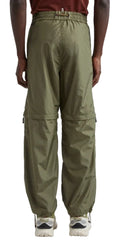 A person shown from the back wearing olive green cargo pants with a zippered waist and side cargo pockets, paired with white sneakers against a light gray studio background.