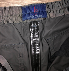 Moncler label on a gray jacket with a wooden background