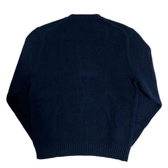 Navy blue sweater on a textured white background
