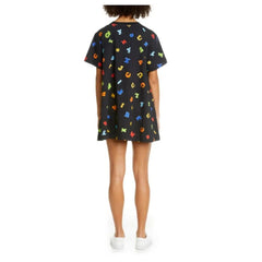 Person wearing a colorful dress with a pattern, standing against a white background