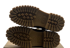 Brown boots with tread pattern on a cardboard box against a white background