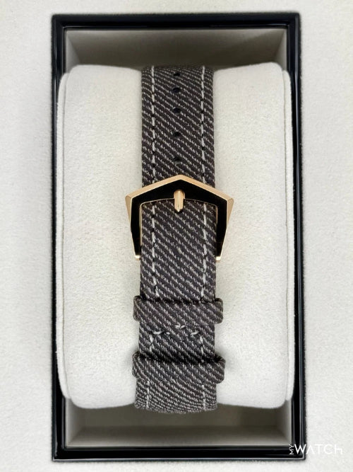 Watch with a textured strap in a box on a white background