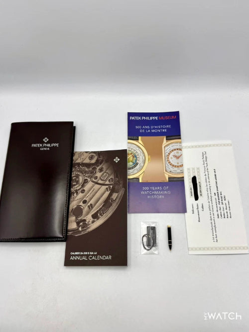 Patek Philippe watch packaging with brochures and accessories on a white surface