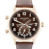 Patek Philippe watch with brown leather strap and black dial on a white background