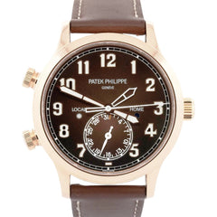 Patek Philippe watch with brown leather strap and black dial on a white background