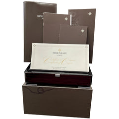 Collection of Patek Philippe documents and certificates in a branded box on a white background