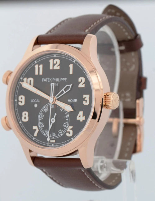 Wristwatch with brown strap and rose gold case on a plain background