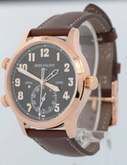Wristwatch with brown strap and rose gold case on a plain background
