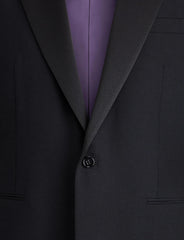 Close-up of a dark charcoal gray suit jacket with a single-button closure, worn over a purple dress shirt.