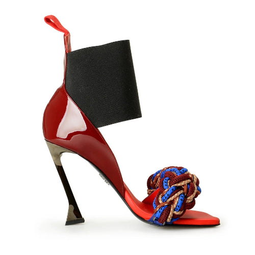 Red high-heeled shoe with a black book on top