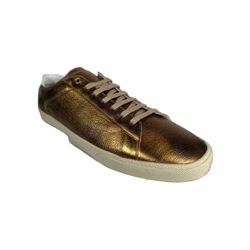 Gold sneaker with beige laces on a white background