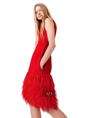 Red dress with feathered bottom half worn by a model on a white background