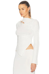 Woman wearing a white long-sleeve top with cut-out design on a white background