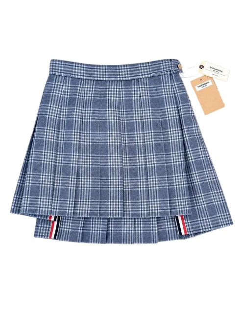 A blue and white plaid pleated mini skirt with a small white bow on the front, shown flat on a textured white background.